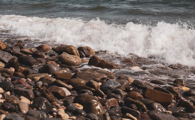 Foto respingos de ondas nas pedras da costa. ondas da costa mediterrânea