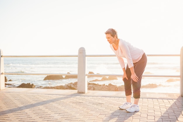 Respirar a mujer deportiva descansando en el paseo