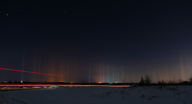 Resplandor multicolor en la atmósfera. Fenómeno natural en el cielo nocturno sobre la carretera.