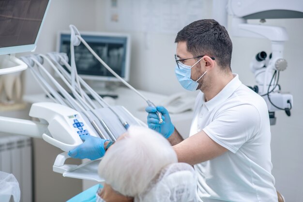 Restauración de dientes. Dentista restaurando los dientes a la paciente senior