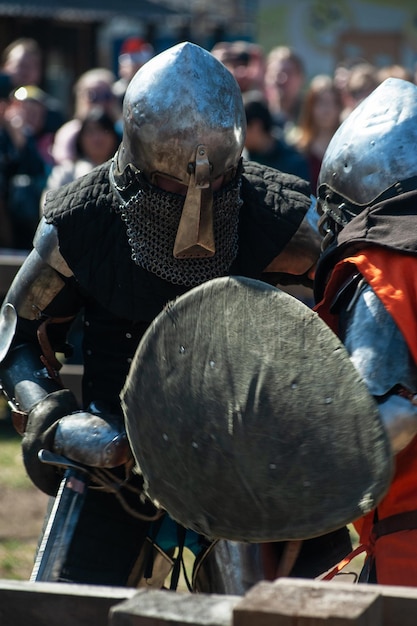 Restauradores medievales luchan con espadas en armadura en un torneo de caballeros restauración histórica de kni