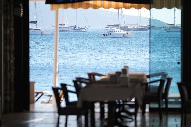 Restaurant am Meer mit Blick auf Schiffe und Berge