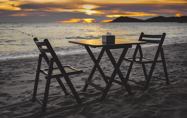 Restaurant Tisch und Stühle am Strand bei Sonnenuntergang