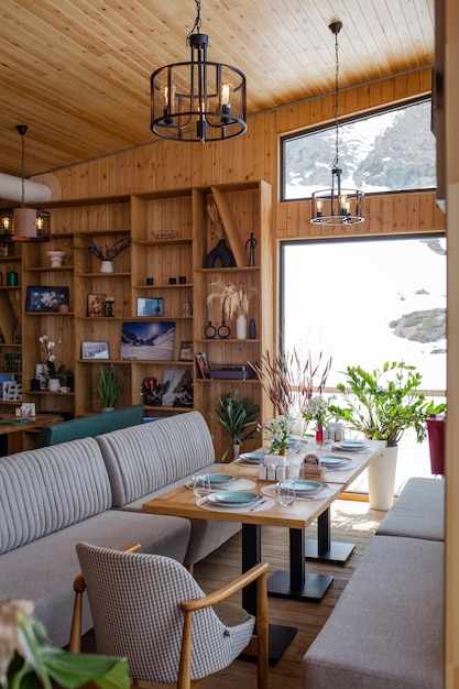 Foto restaurante aconchegante de montanha com painéis de madeira e grandes janelas