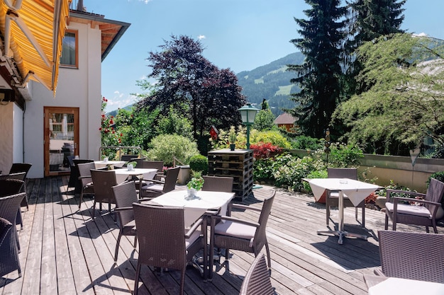 Restaurante callejero con mesas y sillas en el hotel resort en Bad Kleinkirchheim en Carintia, Austria. Diseño de café en la acera. Estilo de vida y naturaleza. Terraza o veranda de cafetería lista para desayunar