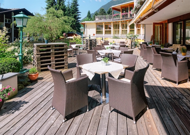 Restaurante callejero con mesas y sillas en el hotel resort en Bad Kleinkirchheim en Carintia, Austria. Diseño de café en la acera. Estilo de vida y naturaleza. Terraza o veranda de cafetería lista para desayunar