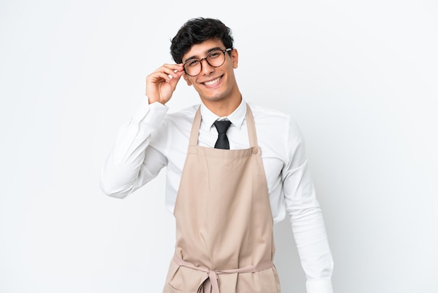 Restaurante camarero argentino aislado sobre fondo blanco con gafas y feliz