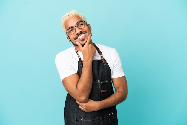 Restaurante camarero colombiano hombre aislado sobre fondo azul sonriendo