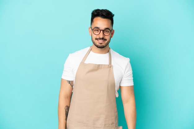 Restaurante camarero hombre caucásico aislado sobre fondo azul con gafas y feliz