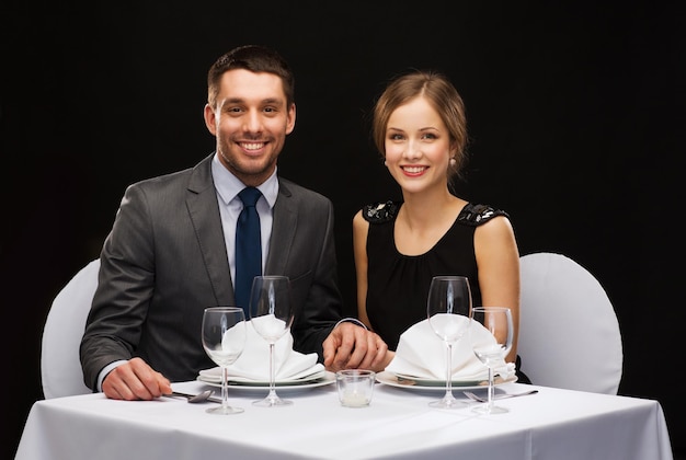 restaurante, casal e conceito de férias - casal sorridente de mãos dadas no restaurante