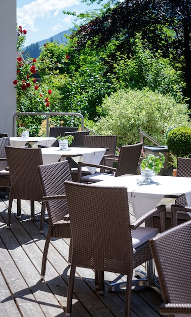 Restaurante de rua com mesas e cadeiras no hotel resort em Bad Kleinkirchheim na Caríntia, Áustria. Projeto do café da calçada. Estilo de vida e natureza. Terraço ou varanda do café pronto para o café da manhã