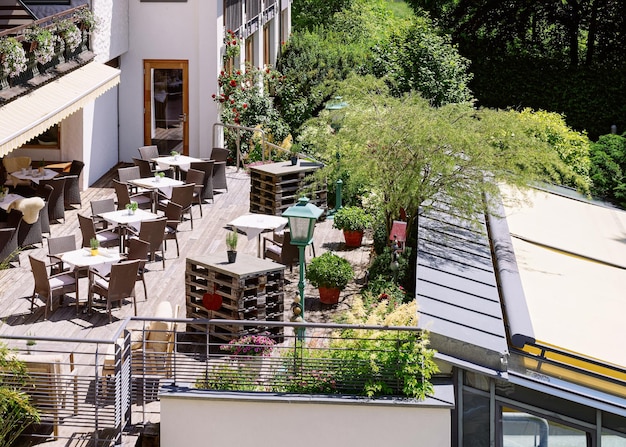 Restaurante de rua com mesas e cadeiras no hotel resort em Bad Kleinkirchheim na Caríntia, Áustria. Projeto do café da calçada. Estilo de vida e natureza. Terraço ou varanda do café pronto para o café da manhã