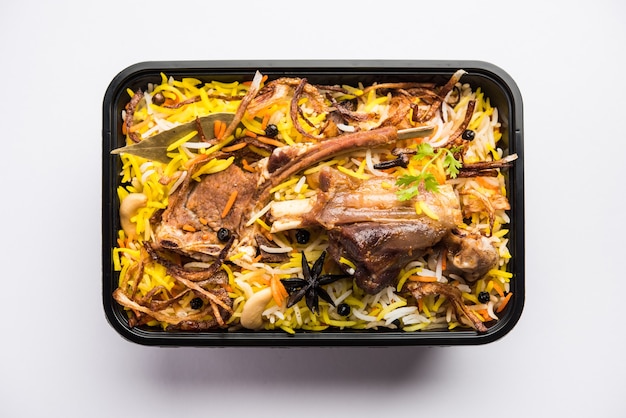 Restaurante estilo Gosht o Mutton Biryani o Pulao empacado para entrega a domicilio en caja de plástico o contenedor con Raita y salan