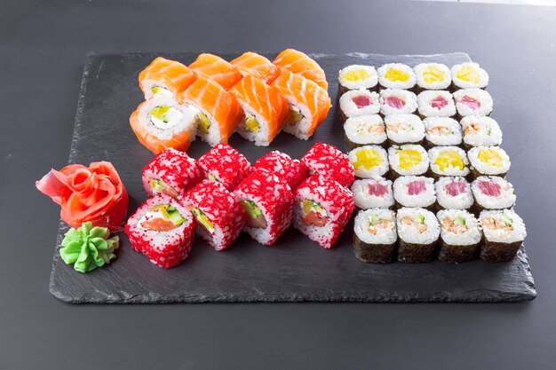 Restaurante japonés, rollo de sushi en placa de pizarra negra.