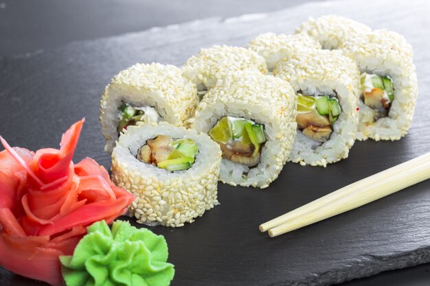 Restaurante japonés, rollo de sushi en placa de pizarra negra.