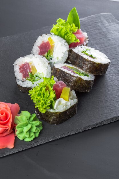 Restaurante japonés, rollo de sushi en plato de pizarra negro,