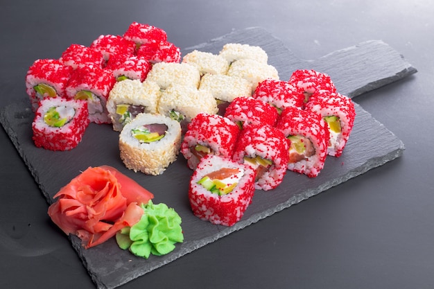 Restaurante japonés, rollo de sushi en plato de pizarra negro.