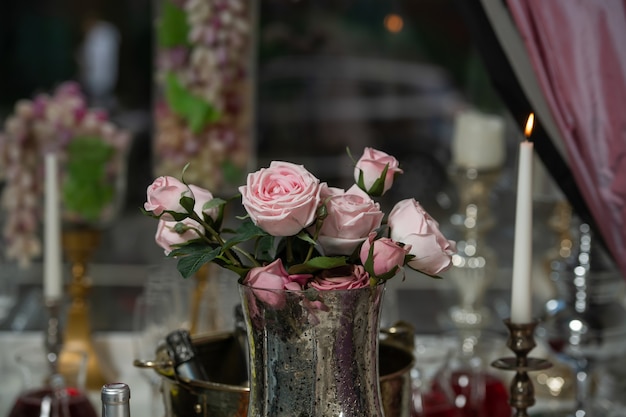 Un restaurante. Un jarrón de rosas rosadas está sobre la mesa. Un lugar romantico.