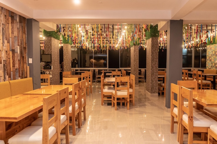 Foto restaurante con mesas y sillas con techo muy colorido