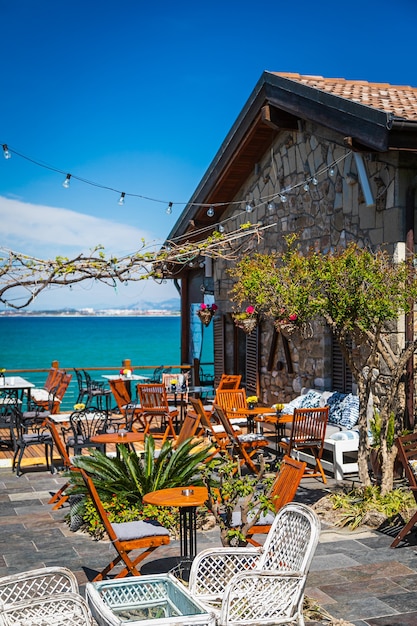 Restaurante con muebles de madera, faroles, palmeras y vegetación