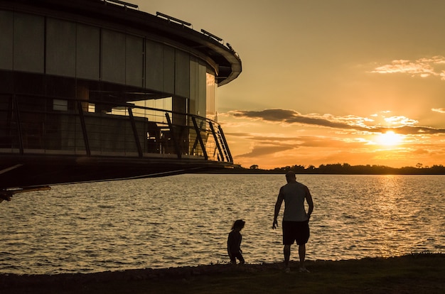 Restaurante panorâmico na orla do Guaba em silhueta ao pôr do sol