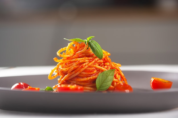 Restaurante de pasta en salsa de tomate, servida en un plato gris. alta cocina