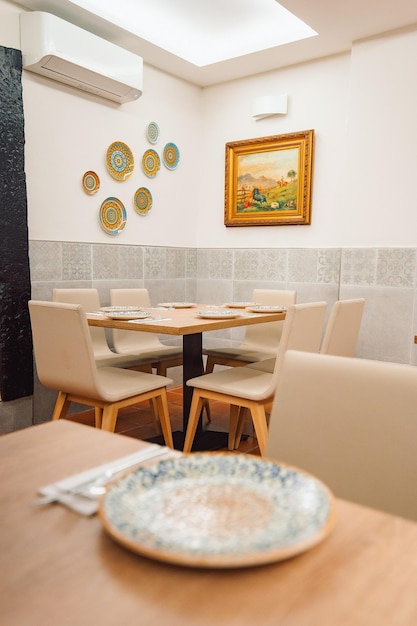 Un restaurante con platos en la pared y un cuadro en la pared.