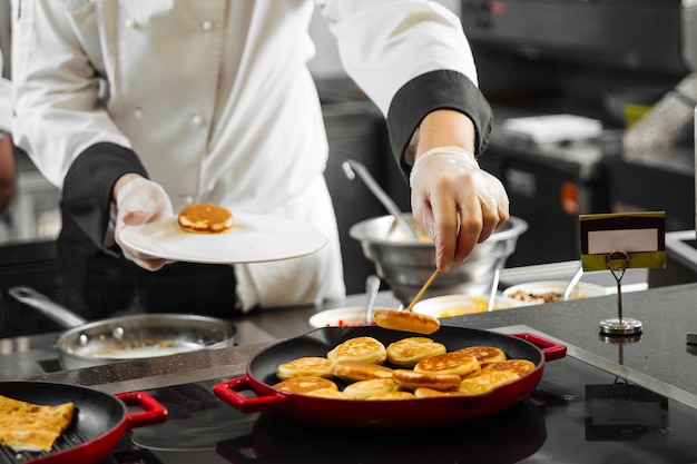 Restaurantkoch, der Pfannkuchen in der Küche kocht