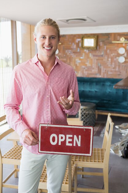 Restaurantmanager hält offenes Schild