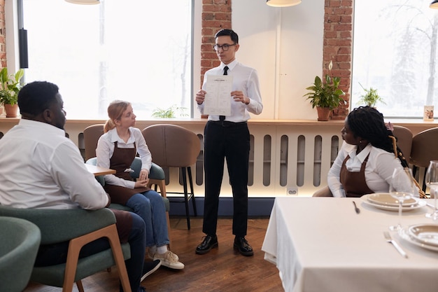 Restaurantmanager zeigt dem Personal das neue Menü