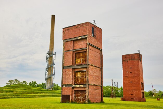 Restos abandonados de antigos edifícios de elevadores de carga da fábrica de vidro e torre de vigia distante