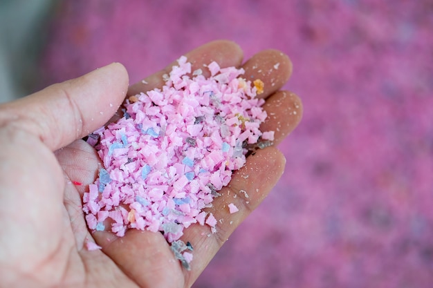 Restos de plástico rosa claro em uma mão