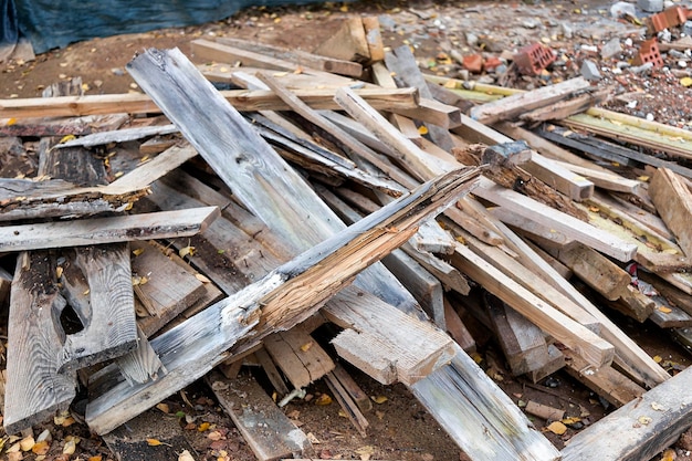Restos de pranchas com pregos após a instalação de fôrmas de concreto Reciclagem de fundo de madeira de sobras de tábuas velhas