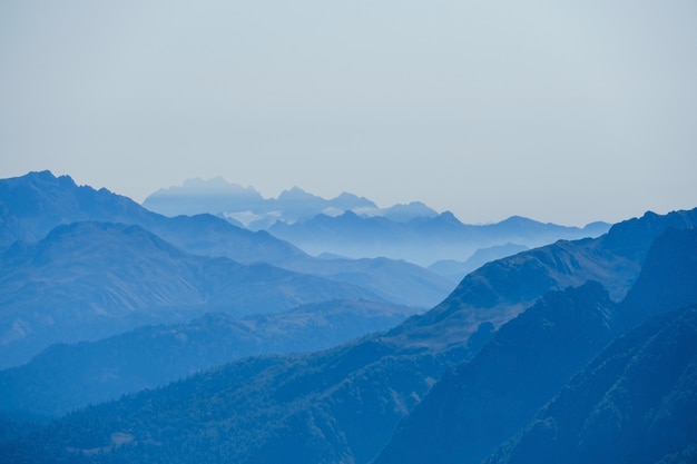 Resumen borroso natural con montañas del Cáucaso en una niebla azul matutina