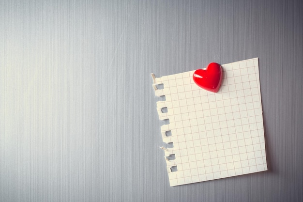 Resumen de clip de corazón de madera con papel en blanco y papel de palo en el espacio de copia de nota de papel de la puerta del refrigerador para agregar texto fondo de mensaje de imagen de San Valentín