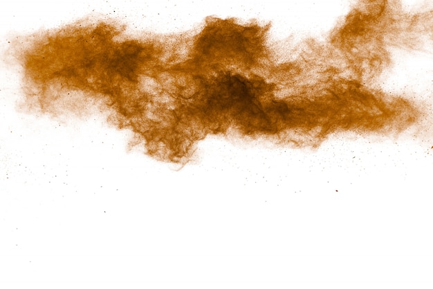 Resumen explosión de polvo marrón oscuro sobre fondo blanco. Congelar movimiento de salpicaduras de polvo marrón.