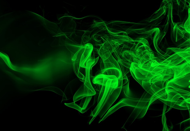 Resumen de humo verde sobre fondo negro, concepto de oscuridad