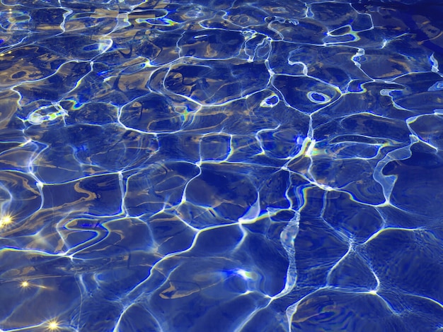 Resumen textura azul del agua de la piscina con reflejos