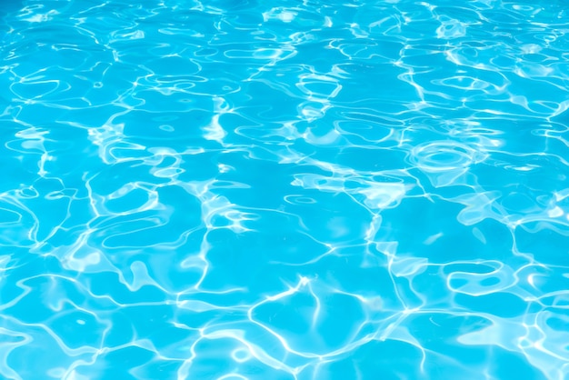 Resumo da superfície da água azul na piscina, onda de ondulação na piscina com reflexos do sol