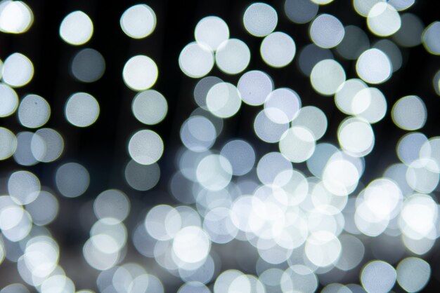 Resumo de bokeh branco azul no papel de parede de fundo preto ou estilo festivo de decoração de pano de fundo