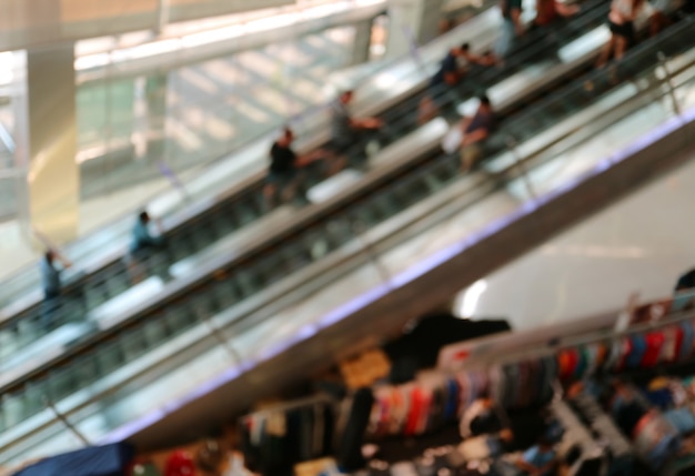 Resumo turva muitas pessoas nas escadas rolantes em um shopping center