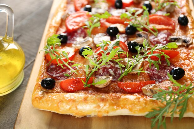 Retângulo deliciosa pizza e legumes na mesa closeup