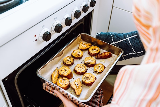 Retire a assadeira do forno com batata doce cozida com especiarias