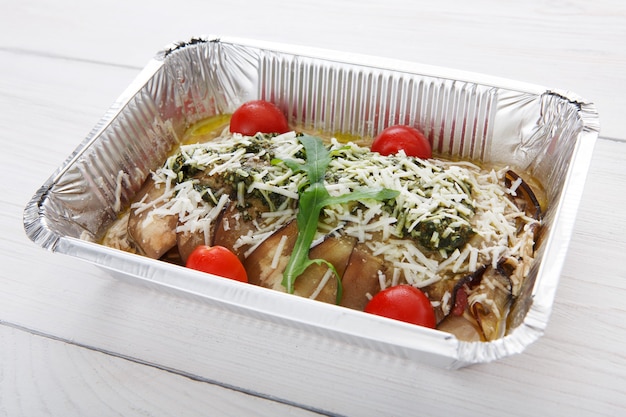Retire os alimentos em caixas de papel alumínio. Ensopado de legumes com berinjela ou berinjela, tomate cereja e queijo parmesão na lenha branca