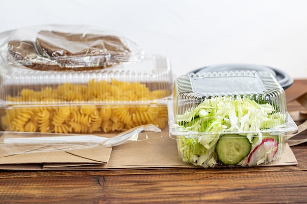 Retire os alimentos em recipientes de plástico. salada e macarrão fusilli