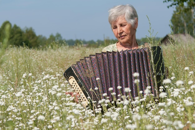 Retrato de abuela con acordeón en verano