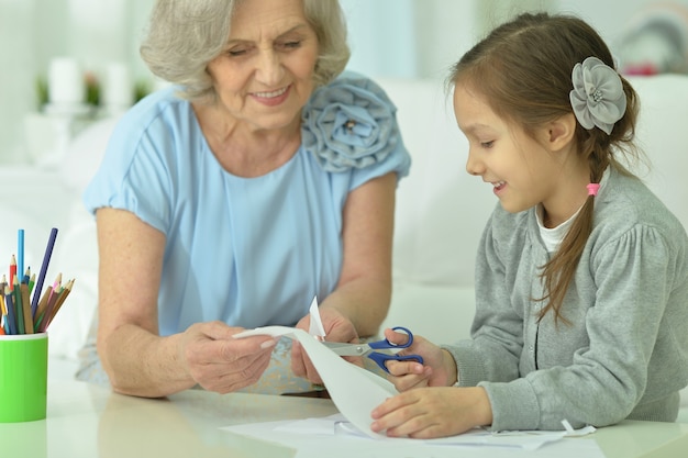 Retrato de una abuela feliz con nieta cortando juntos