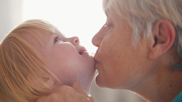 Retrato de abuela y nieta abuela besando a su nieta