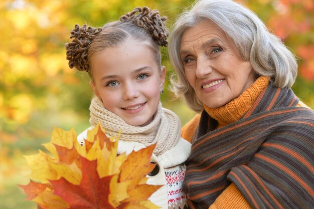 Foto retrato de abuela y nieta posando al aire libre