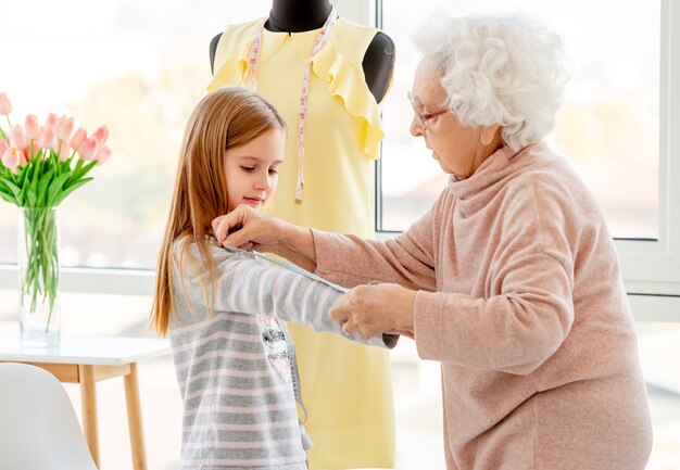 Retrato de abuela y nieta en un taller